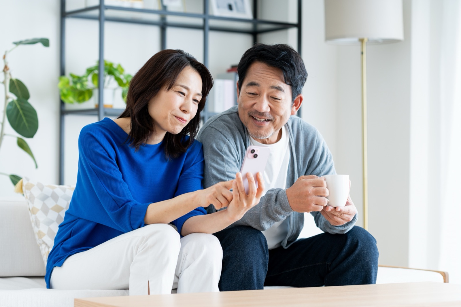 LINEに届いた学習記録を、リビングで一緒に確認する夫婦（イメージ）