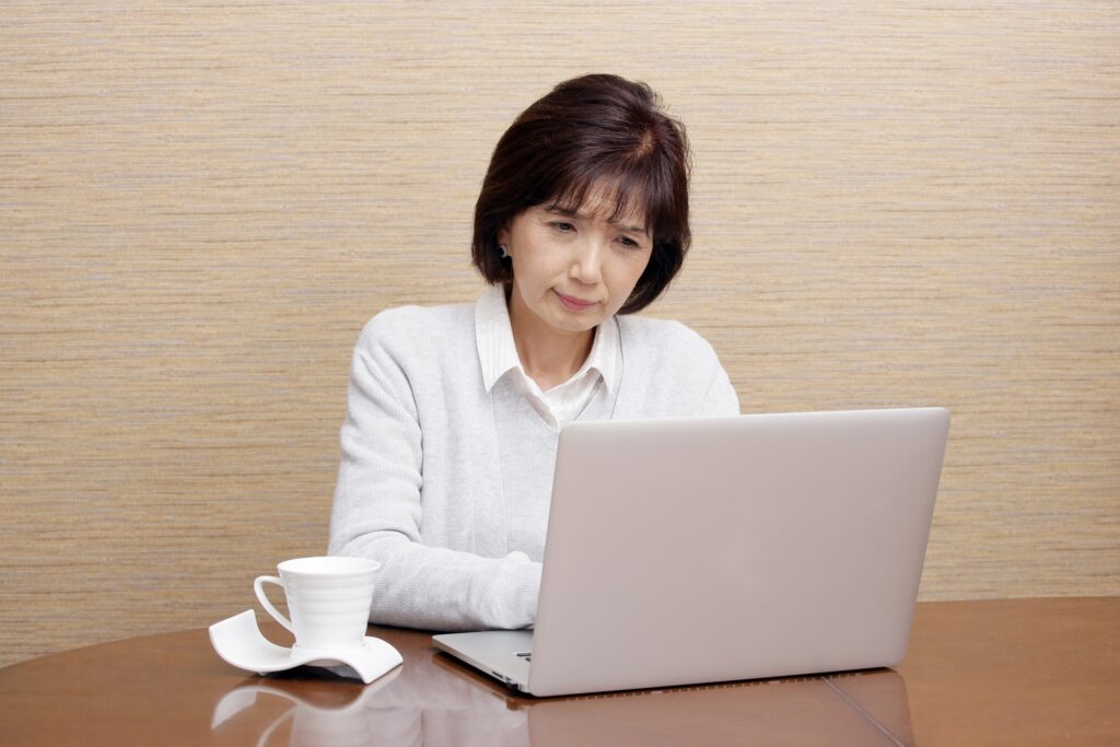 PCを見て悩む母親